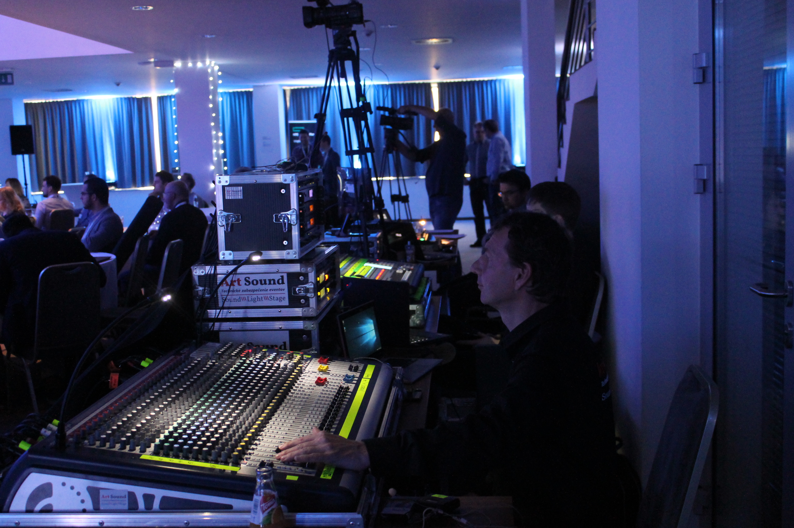 Mixážny pult a zvukár obsluhujú konferenciu spolu s kamerovou technikou a osvetlením sály